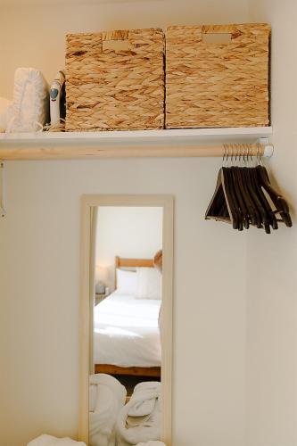 two images of a bedroom with a mirror and a bed at Cozy Downtown Havens in Moscow