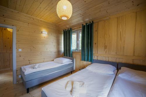 a room with two beds in a wooden cabin at Szafranowe Wzgórze III-Dom z parkingiem, Sauna, zew Jacuzzi in Karpacz