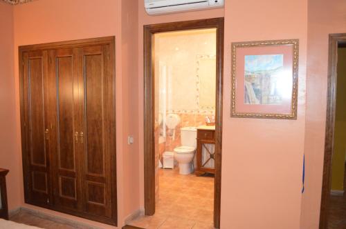 a bathroom with a toilet and a picture on the wall at Hotel Don Javier in Ronda