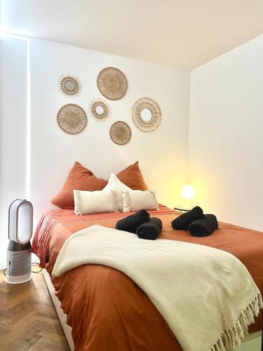 - une chambre avec 2 lits avec chapeaux sur le mur dans l'établissement Lyon Suite Cosy - Climatisé - Appartement T2 - Proche Parc Tête d'Or, à Villeurbanne