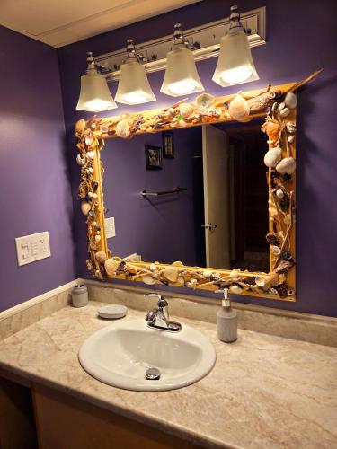 a bathroom with a sink and a large mirror at Ocean's Edge in Port Alice