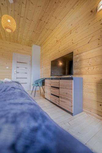 a bedroom with a bed and a dresser with a tv at Szafranowe Wzgórze II-Dom z parkingiem, Sauna, zew Jacuzzi in Karpacz