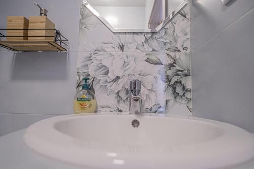 a sink in a bathroom with a flower wallpaper at Szafranowe Wzgórze II-Dom z parkingiem, Sauna, zew Jacuzzi in Karpacz