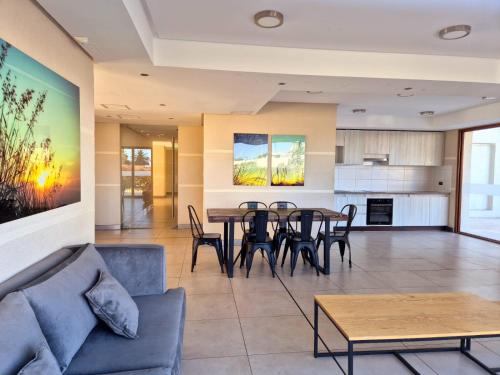 Una sala de estar con mesa y sillas y una cocina. en Departamento a pasos de Enjoy, en Coquimbo