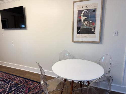a white table with chairs and a tv on a wall at Dreami Stays Panama City - 2BR Retreat Near Downtown, Beaches, & Hot Spots in Panama City