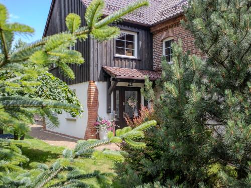 a house with a black roof and trees at Na Uboczu in Gryfów Śląski