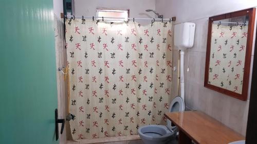 a bathroom with a shower curtain with a toilet at Cabaña para 6 personas en parada 18 in Barra del Chuy