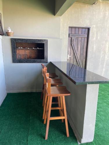 a bar with a counter and stools in a room at Casa da Lagoa in Tramandaí