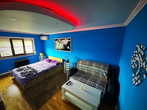 a bedroom with a bed and a couch and a red ceiling at Apartament nemaipomenit de frumos Super accesibil in Botoşani