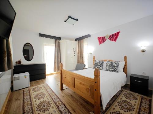 a bedroom with a large bed and a mirror at Casa Șaru Bucovinei in Şaru Bucovinei