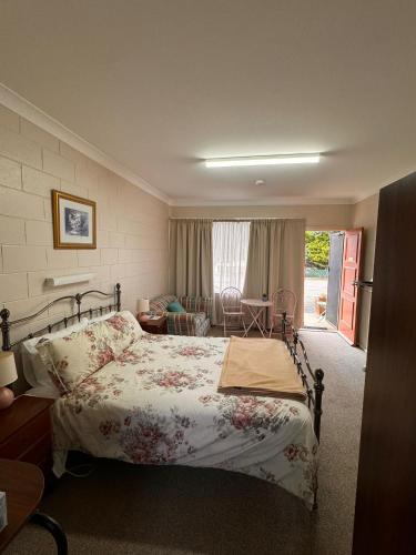 a bedroom with a bed and a living room at ALPINE COUNTRY MOTEL plus FREE COFFEE in Cooma