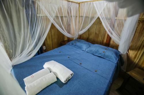 a blue bed with two towels on top of it at Posadas Ecoturisticas Seineken in El Zaino