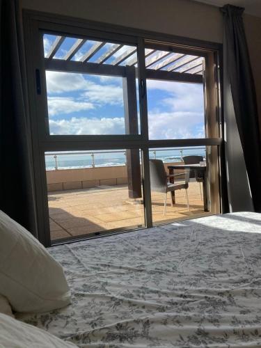 a bedroom with a view of the ocean through a window at Beach Apartment Marfolin 17 El Cotillo Adults Only in El Cotillo