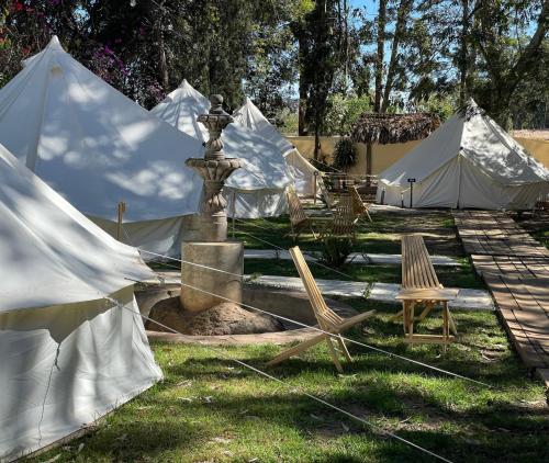 a group of tents with a fountain in the grass at Taanah Glamping in Zapotlanejo