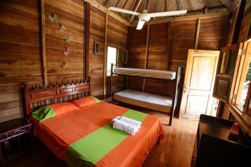 a bedroom with a bed in a wooden cabin at Posadas Ecoturisticas Seineken in El Zaino