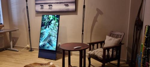 Cette chambre dispose d'un écran de jeux vidéo, d'une table et d'une chaise. dans l'établissement Appartement centre ville Hôtel Particulier, à Carpentras