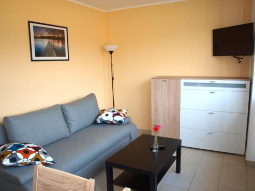 a living room with a blue couch and a table at Ferienwohnung Graal Müritz im Igelring in Graal-Müritz