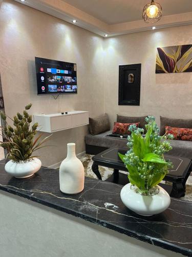 una sala de estar con 2 jarrones blancos sobre una mesa en Studio, en Marrakech