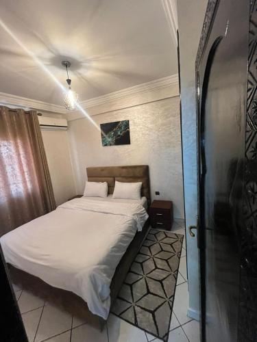 Un dormitorio pequeño con una cama con sábanas blancas. en Studio, en Marrakech