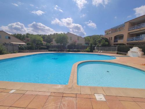 une grande piscine bleue dans une cour dans l'établissement 2 bedroom end of terrace house, au Beausset