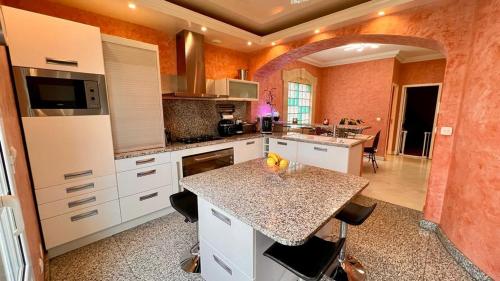 - une cuisine avec des placards blancs et un plan de travail en granit dans l'établissement Maison spacieuse à Chelles, à Chelles