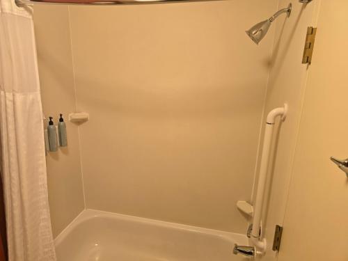 a bathroom with a shower and a white tub at Country Inn & Suites by Radisson, Convention Center in Altoona