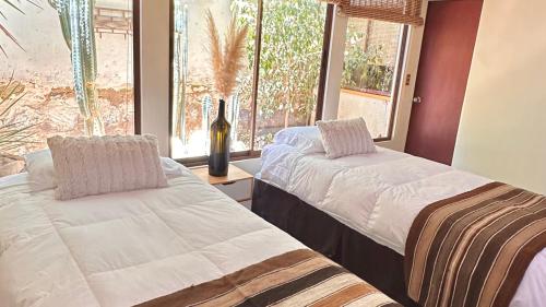 two beds in a room with a window at Hostal RustiKo Experiencias in Diaguita