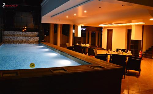 a pool in a restaurant with a bar and tables at Sepoy Grande Mysore in Mysore