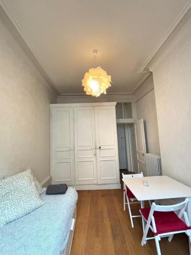 une chambre avec un lit, une table et un lustre dans l'établissement Studio cocon proche de la gare, à Clermont-Ferrand