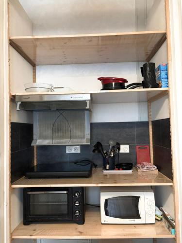 - une cuisine avec deux fours micro-ondes et des appareils sur étagères dans l'établissement Studio cocon proche de la gare, à Clermont-Ferrand