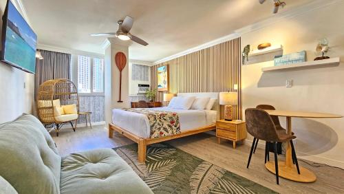a hotel room with a bed and a table at Waikiki Grand Hotel Official Site in Honolulu