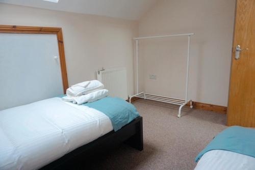 a bedroom with two beds and a mirror at Laxey place maisonette East Belfast -private parking, transport links in Belfast