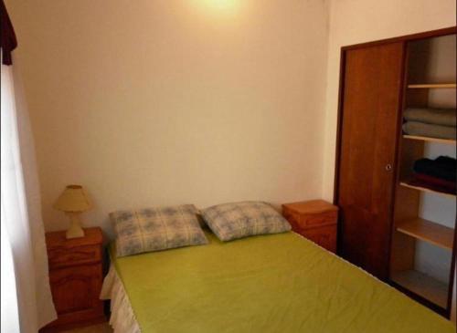 a bedroom with a green bed with two pillows at Duplex a 5 cuadras del mar con WiFi y TV Calle 36 y 6 in Santa Teresita