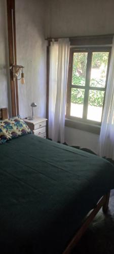 a bedroom with a green bed and a window at Un lugar en el mundo in Chapadmalal