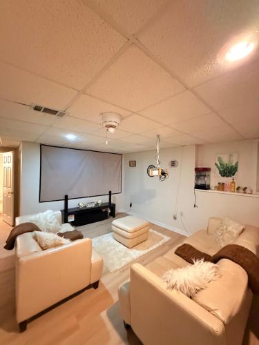 a living room with two couches and a projection screen at Oasis Zen Space in Kennesaw in Kennesaw