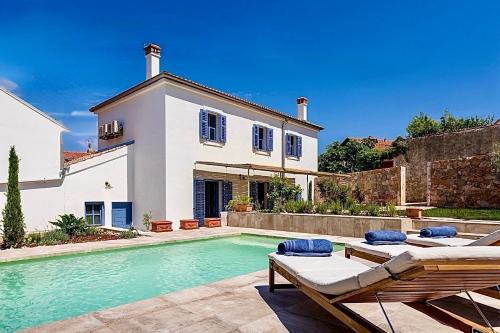 a swimming pool in front of a house at Casa Guarda Island Lošinj in Veli Lošinj
