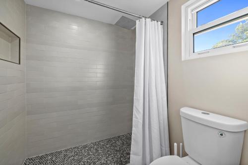 a bathroom with a white shower curtain and a toilet at Chadwick Cove Marina in Englewood