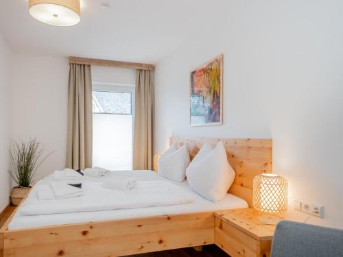 sypialnia z drewnianym łóżkiem i oknem w obiekcie Ski Nature Apartment Lungau Top 8 w mieście Mauterndorf