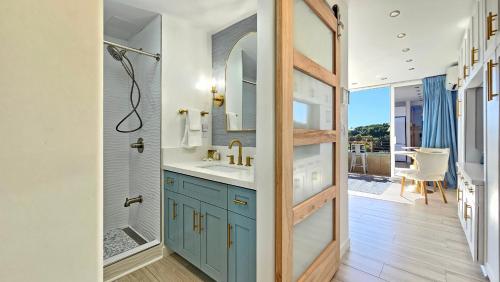 a bathroom with a sink and a mirror at Waikiki Grand Hotel Official Site in Honolulu