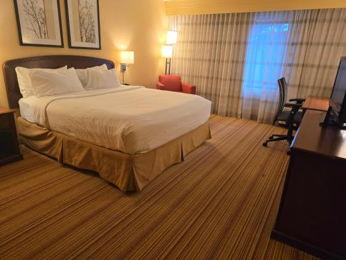 a hotel room with a bed and a desk and chair at Country Inn & Suites by Radisson, Convention Center in Altoona