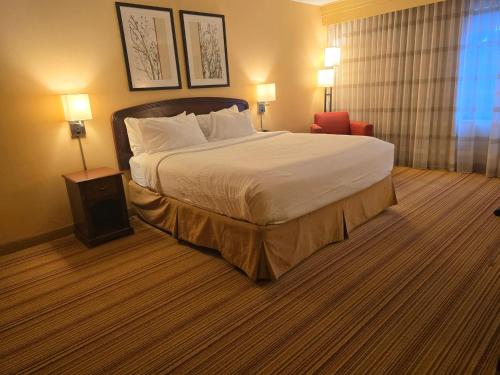 a hotel room with a large bed and a chair at Country Inn & Suites by Radisson, Convention Center in Altoona