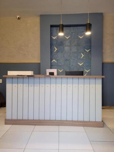 a lobby with a white counter and a blue wall at Sol do Centro Pousada in Fortaleza