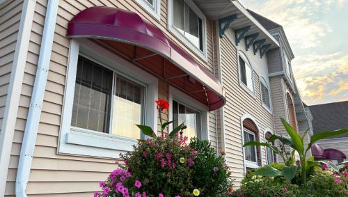 a house with a window with a flower in a bush at Magnuson Grand Pioneer Inn and Suites in Escanaba