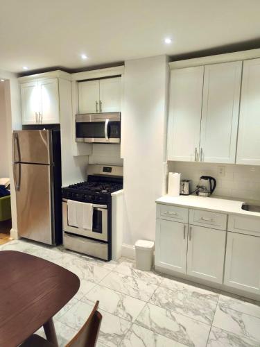 a kitchen with white cabinets and stainless steel appliances at Jersey City Private Entire Apartment - 30 Minutes From Wall St New York City in Jersey City