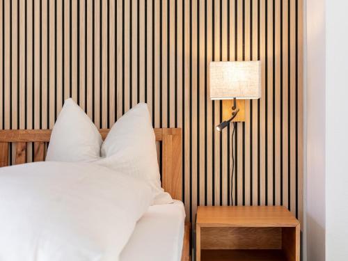 a bedroom with a bed and a lamp and a table at Brixen Alpin Living Top 1 in Brixen im Thale