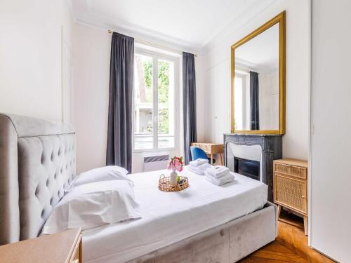 Un dormitorio con una cama con un espejo y una mesa. en Charming appt 2BDR 4P - Mairie de Neuilly, en Neuilly-sur-Seine