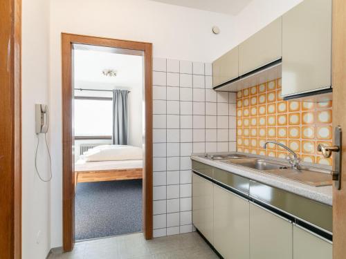 a kitchen with a sink and a bed in a room at Brixen Alpin Living Top 1 in Brixen im Thale