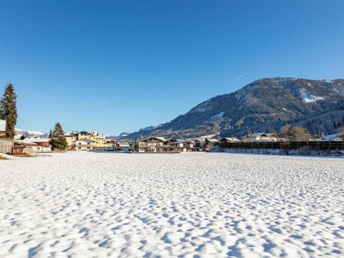 a snowy beach with houses and mountains in the background at Brixen Alpin Living Top 5 in Brixen im Thale