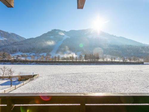 a view of a snow covered lake with the sun in the background at Brixen Alpin Living Top 11 in Brixen im Thale