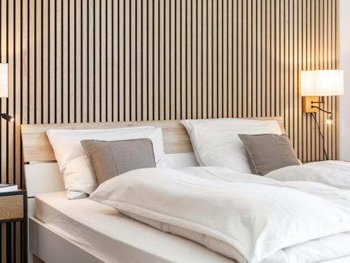 a bedroom with two white beds and a striped wall at Brixen Alpin Living Top 13 in Brixen im Thale